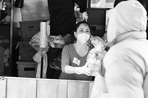 Person with mask giving food to someone